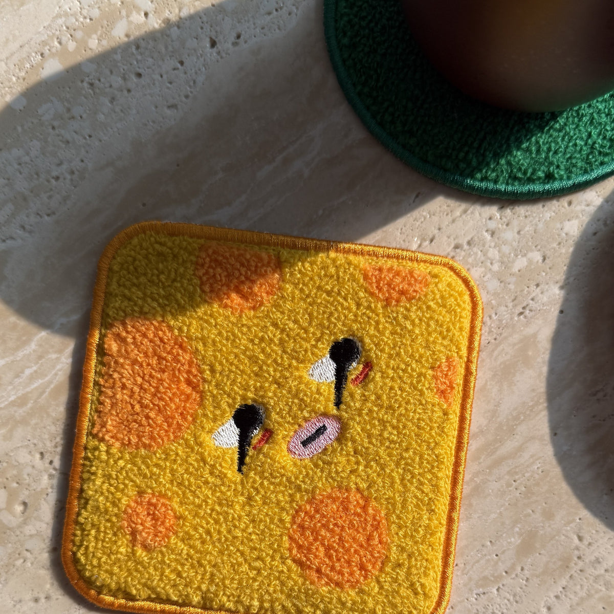 Daging Burger Coaster Stack — cheese coaster on a sunlit table