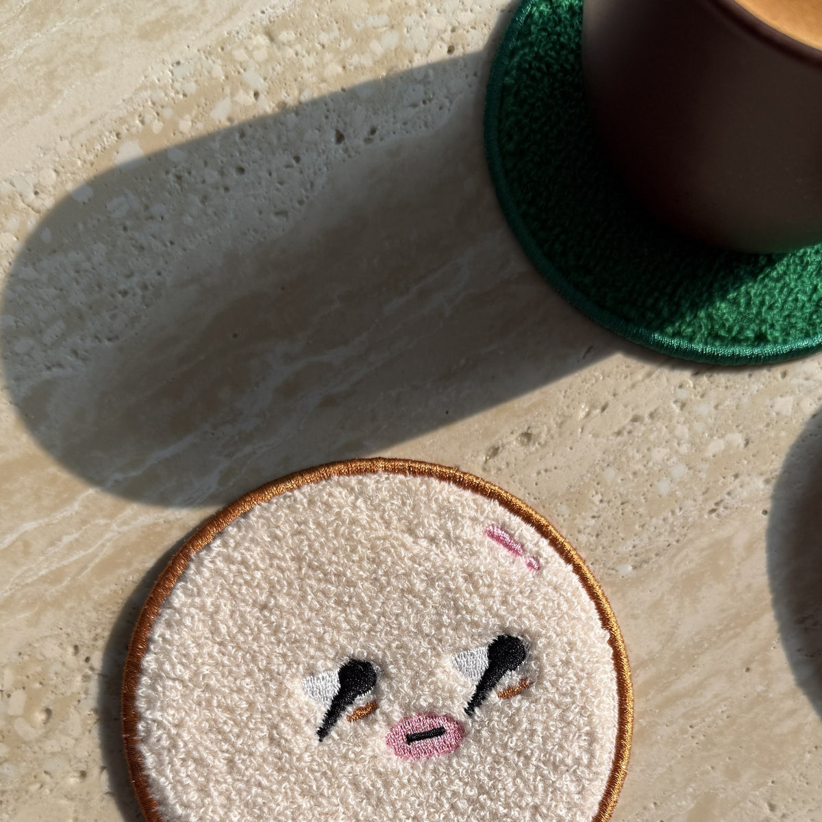 Daging Burger Coaster Stack — bottom bun coaster on a sunlit table